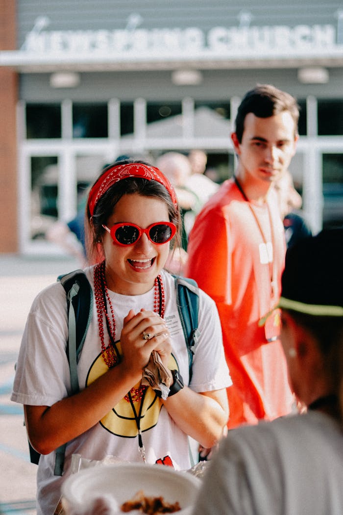 A cheerful church event with young adults enjoying fellowship and community at an outdoor summer gathering.
