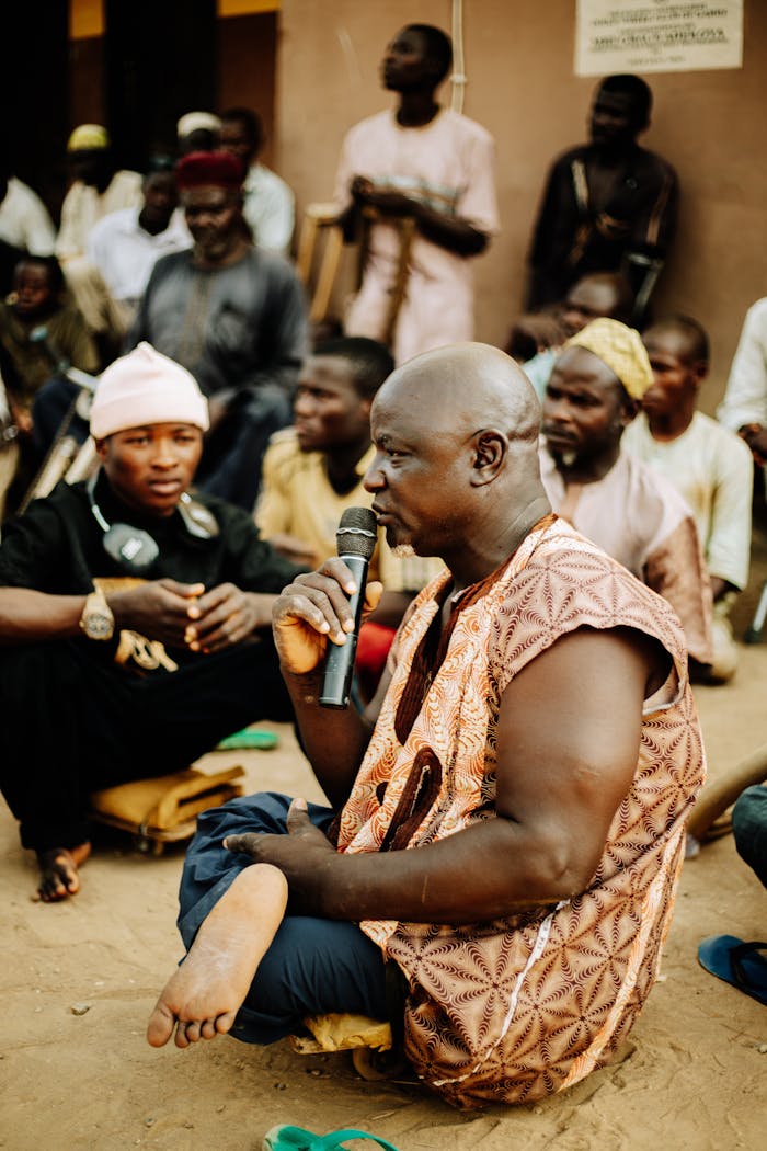 A community leader speaks to a group gathered outdoors, highlighting unity and tradition.
